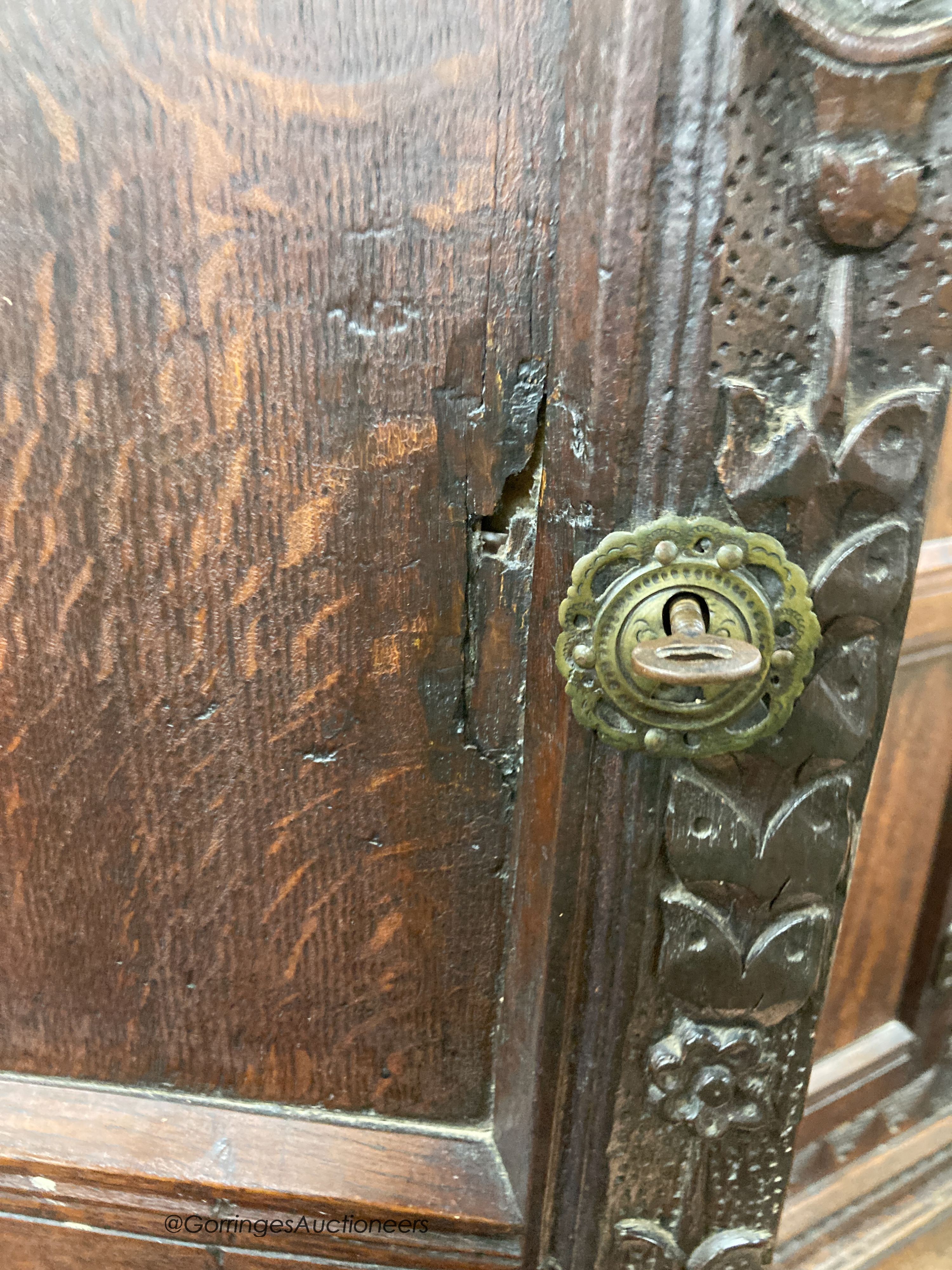 A carved oak cupboard, enclosed by panelled doors, bearing monograms and dated 1601, width 138cm, depth 53cm, height 218cm